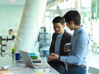 Two businessman talking to each other while take a coffee break in meeting room