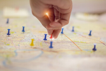 Soft focus hand holding paper pin on blur perspective road map,copy space.filter color effect.