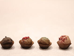 chocolate candies on beige background with a copy space