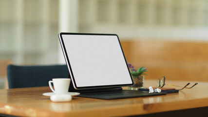 Digital tablet include clipping path, accessories and coffee cup on wooden table