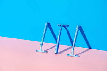 Disposable razor on blue and pink background