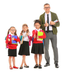 Little schoolgirls with teacher on white background