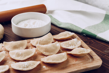 Raw stuffed russian dumplings on wooden board