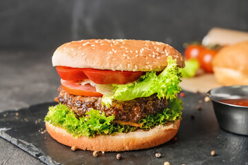 Tasty burger on dark background
