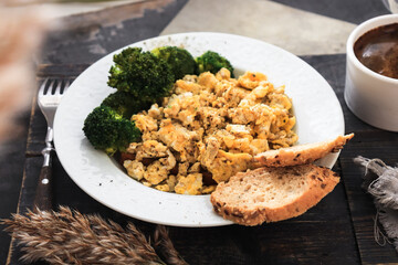 Scrambled eggs in a white plate. Scrambled eggs and broccoli. Healthy breakfast or lunch.