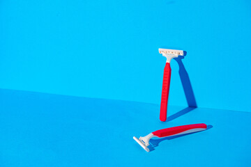 Disposable razors on blue background, studio shot