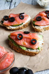 Toast with salmon and olives. Salmon and avocado sandwiches. Vertical view