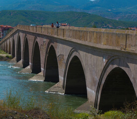 Historical Ottoman stone bridge and Kızılırmak. River and bridge view. Rural settlement and arched structure. 