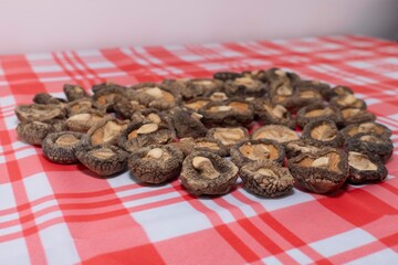 Shiitake mushroom caps are arranged in a heart shape on the table.