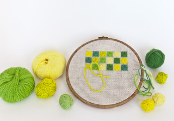 Needlework and hand embroidery as a hobby. The process of embroidering green and yellow volumetric...