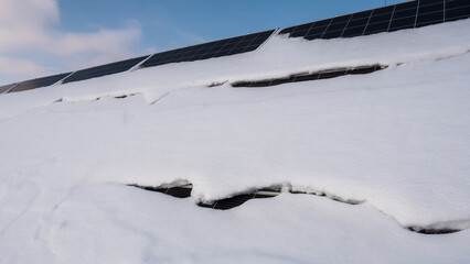 Obraz premium A layer of snow on the panels of a solar power plant. Green energy problems and weather dependence