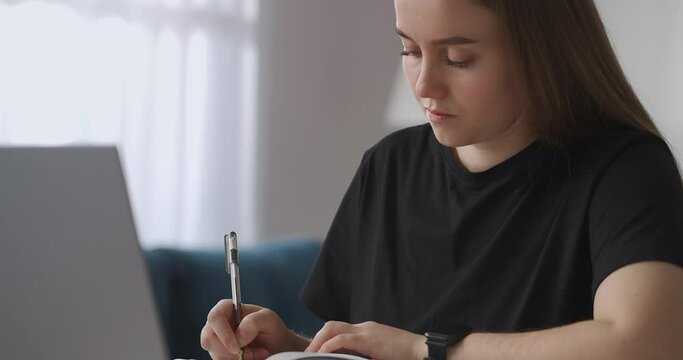 Home Education Of Student Or High Schooler, Teen Girl Is Viewing Online Lecture On Laptop And Writing Homework