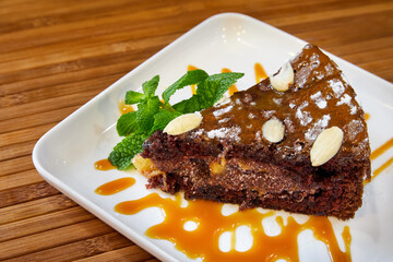 Chocolate cake with fruits and nuts, topped with caramel. Close-up, selective focus