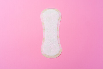 Female hygienic pad on pink background top view