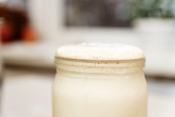 Yeast sourdough in a glass jar. The concept of baking at home.