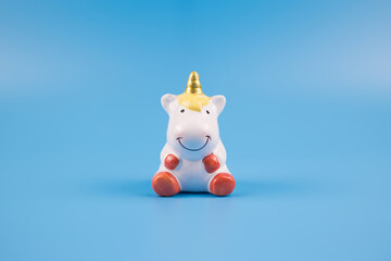 Figurine of a smiling unicorn on a blue background © Kristina
