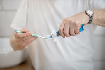 Man in white tshirt doing morning procedures in a bathroom