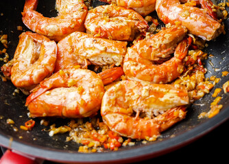 Close-up Thai stir fried prawns with chillies and salt on pan, cooking spicy Thai food on pan