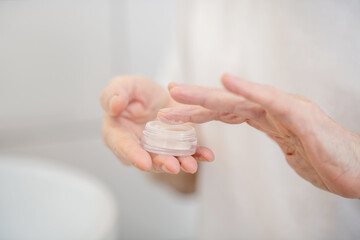 Close up of human hands holding a jar of cream
