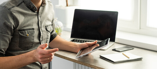 Smiling young man freelancer using laptop, studying online, working from home, happy casual guy...