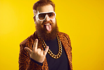 Studio portrait of funny eccentric rich bearded chubby young man in sunglasses, extravagant funky...