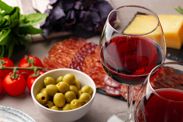 Meat slicing and wine on gray background