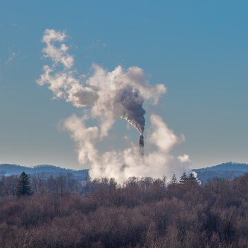 Smokestack emissions from coal fired powerplants photographed against a rural West Virginia backdrop