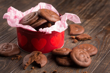Homemade Baked Creamy chocolate cookies in festive red gift box on dark wooden texture background.