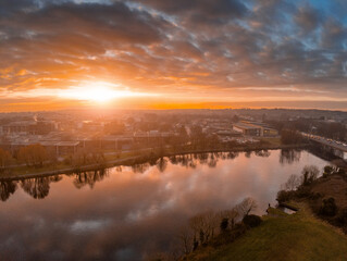 Beautiful sunset over Galway city, Ireland, Corrib river, Blue and orange color cloudy sky. Aerial view. Calm and peaceful atmosphere