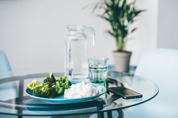Using Smart Phone While Eating Broccoli and rice at home.