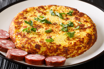 LuxembourgTierteg mashed potato pancakes with bacon and sauerkraut, served with sausages close-up in a plate on the table. Horizontal