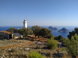 Fototapeta na wymiar Gelidonya Lighthouse at cape in Mediterranean sea. Lighthouse and three Islands on Lycian Way in. Karaoz, Antalya, TURKEY