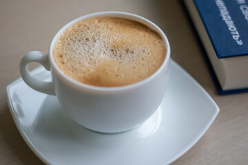 Cup of Morning cappuccino coffee with milk and blue book photography