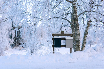 Letterboxes lined up in a a snow-covered winter atmosphere.