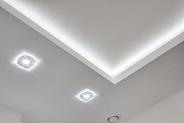 suspended ceiling with halogen spots lamps and drywall construction in empty room in apartment or...