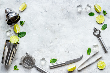 Flat lay of cocktail bar utensils and ingredietns - shaker, lime and ice