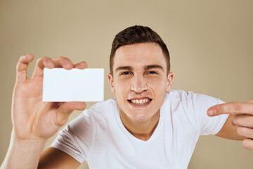 Man with a business card in the hands of an office manager beige background Copy Space