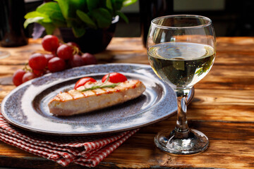 Grilled chicken breast served with cherry tomatoes on table