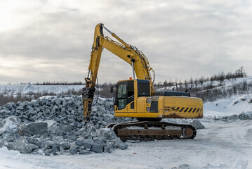 Excavator with hydraulic hammer splits rocks