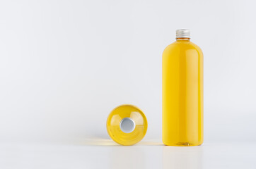 Set of two transparent plastic tall bottles standing and lying with orange liquid, oil or cosmetic produce and silver cap, mockup on white background,  front and top view.