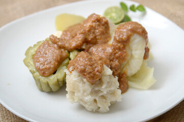 Siomay is an Indonesian steamed fish dumpling with vegetables served in peanut sauce. Somay serve in plate with cabbage, bitter melon, tofu, and potatoes