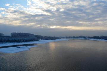 Beautiful landscape with river under cloudy sky in winter