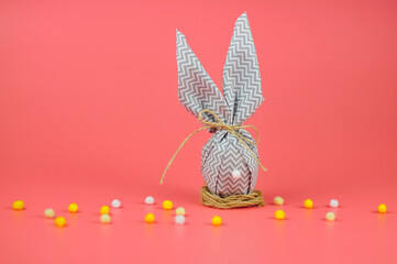 Happy easter. egg with bunny ears on a pink background. DIY eggs decorated with homemade.