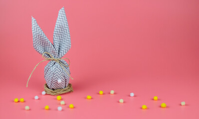 Happy easter. egg with bunny ears on a pink background. DIY eggs decorated with homemade.