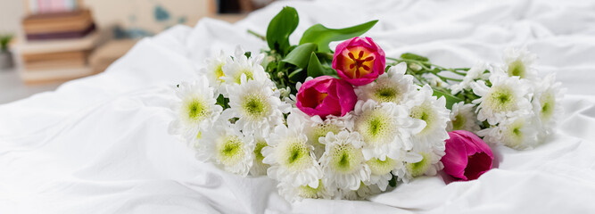 Obraz na płótnie Canvas Tulips and chrysanthemums on white bedding, banner
