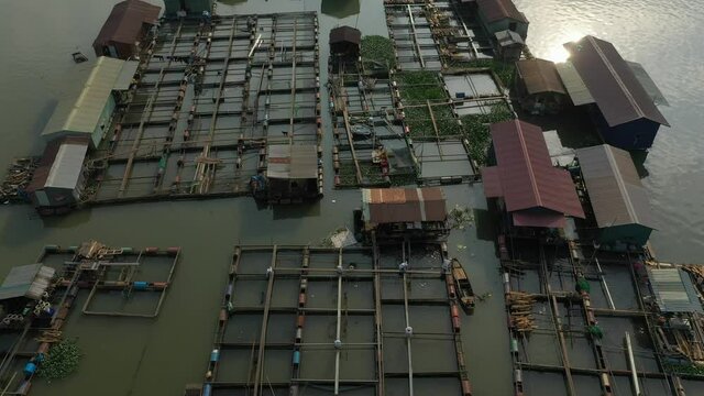 top down drone crane shot flying over floating fish farming community in Bien Hoa on the Dong Nai river, Vietnam on a sunny day