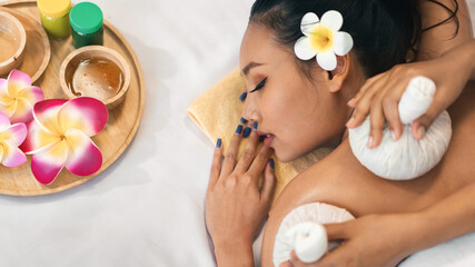 Obraz na płótnie Canvas Beautiful young Asian woman relaxing with natural thai massage spa treatment in the spa salon, lifestyle beauty woman concept, Top view.