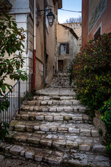 Fototapeta na wymiar street scene with stairs leading into village ,Fontaine de Vaucluse , Provence ,france .
