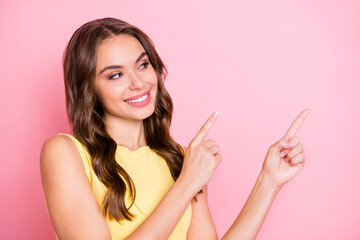 Photo of pretty positive girl look direct two arms fingers empty space good mood isolated on pink color background
