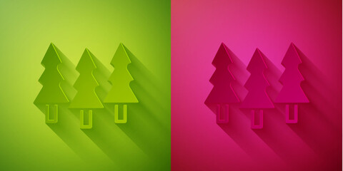 Fototapeta premium Paper cut Trees icon isolated on green and pink background. Forest symbol. Paper art style. Vector.